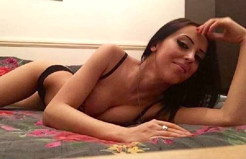 Claudia laying on her bed in black lingerie