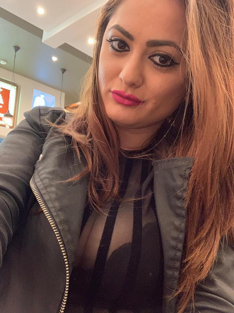 Teo showing her cleavage in a black dress and leather jacket